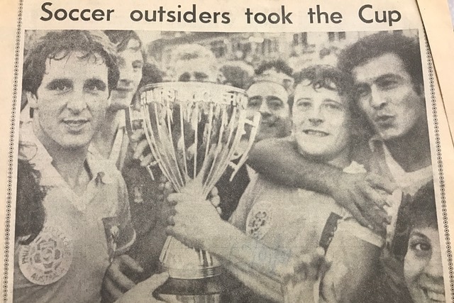 A newspaper clipping shows Ian Rathmall holding the NSL Cup surrounded by supporters
