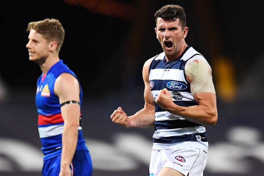 A Geelong AFL player pumps both his fists as he celebrates a goal against the Western Bulldogs.