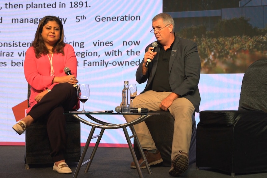 Photo of a man and a woman on stage talking.