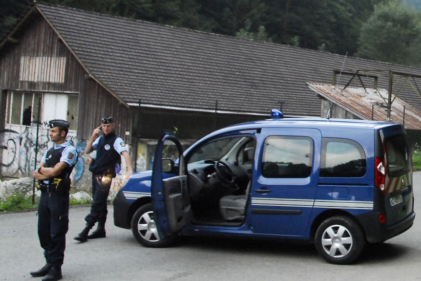 French gendarmes block the road leading to the scene where four people died in a shooting at a car park in the French Alps.