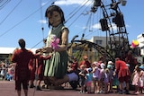 Little girl giant kneels before the Perth crowds