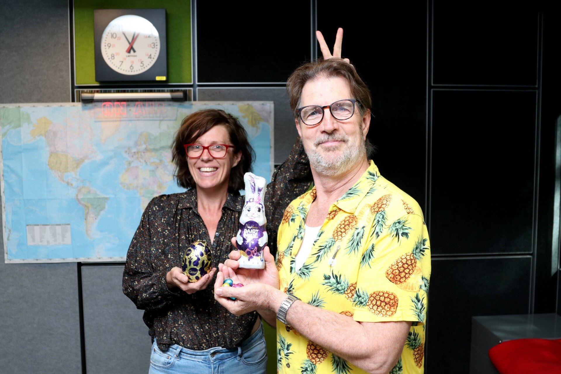 A man in a colourful shirt next to a woman holding Easter chocolates.