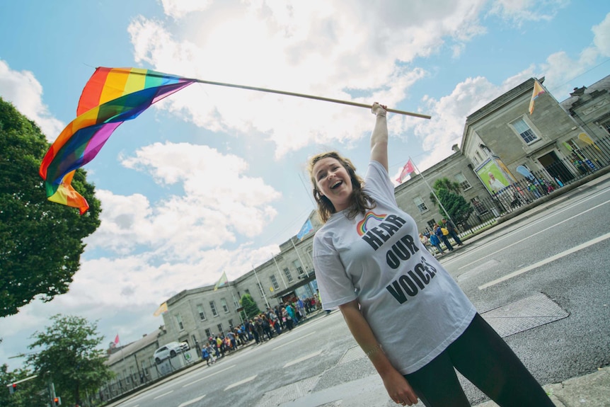 Siofra Kelly waves a rainbow flag