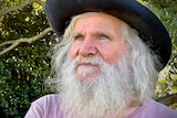 A man with a long grey beard and wearing a hat.