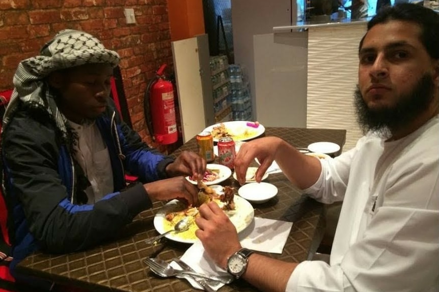 Two men eat in a restaurant.