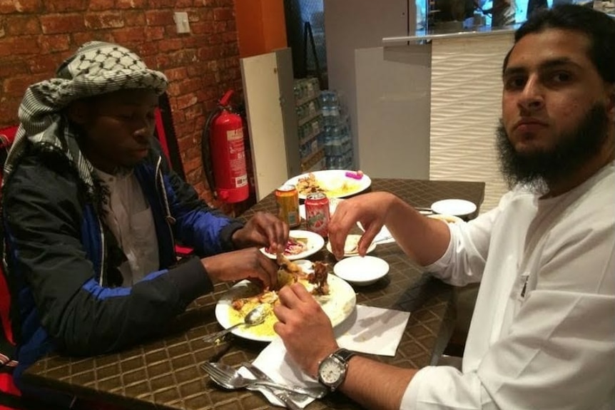 Deux hommes mangent dans un restaurant.