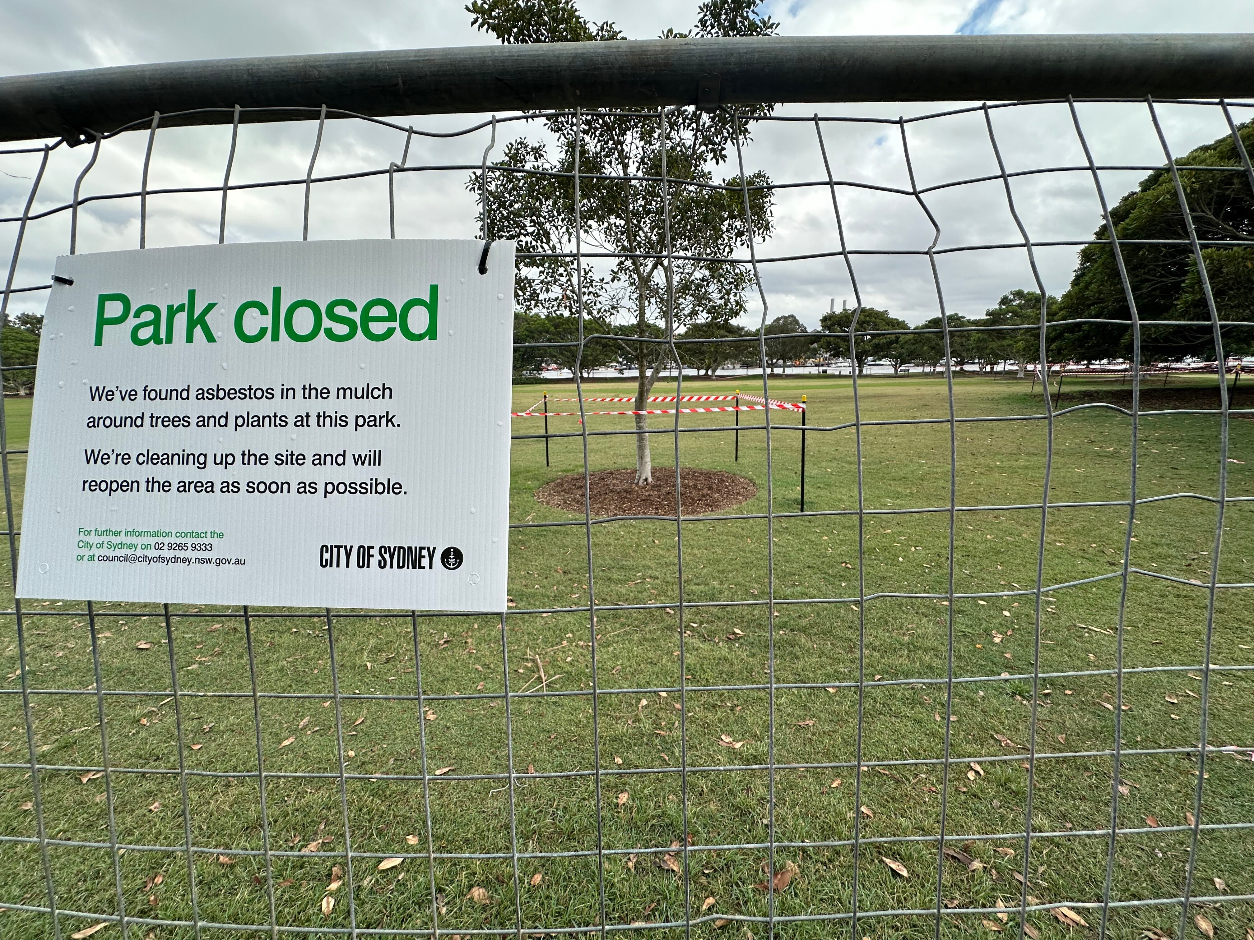 Park Closed sign on fence with tree taped off in the background.