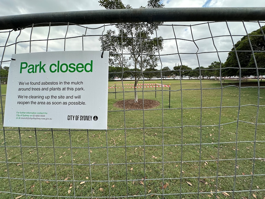 Park Closed sign on fence with tree taped off in the background.