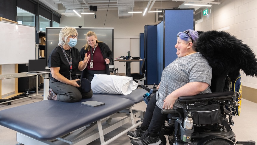 Researchers with a wheelchair user in a laboratory.