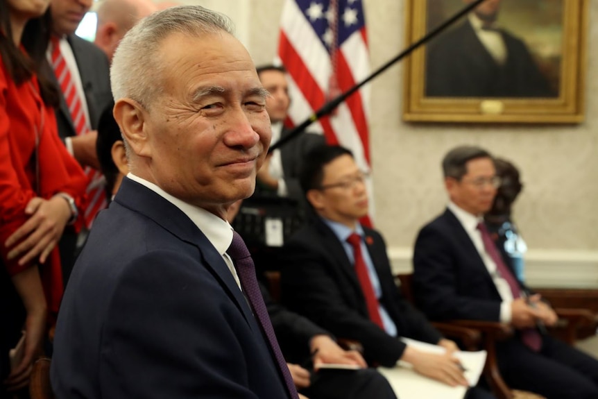 Liu He smiles at a camera in the White House Oval Office