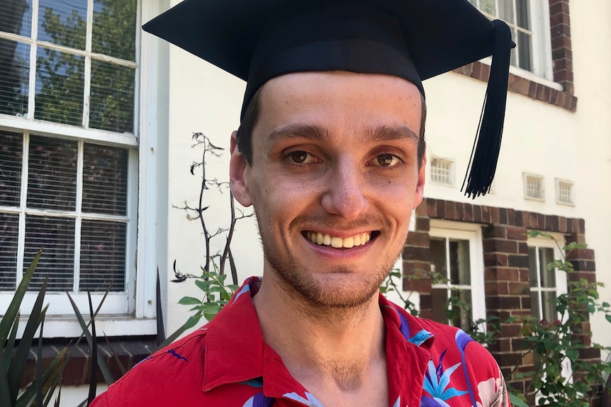 Young man in a red shirt with a graduation cap