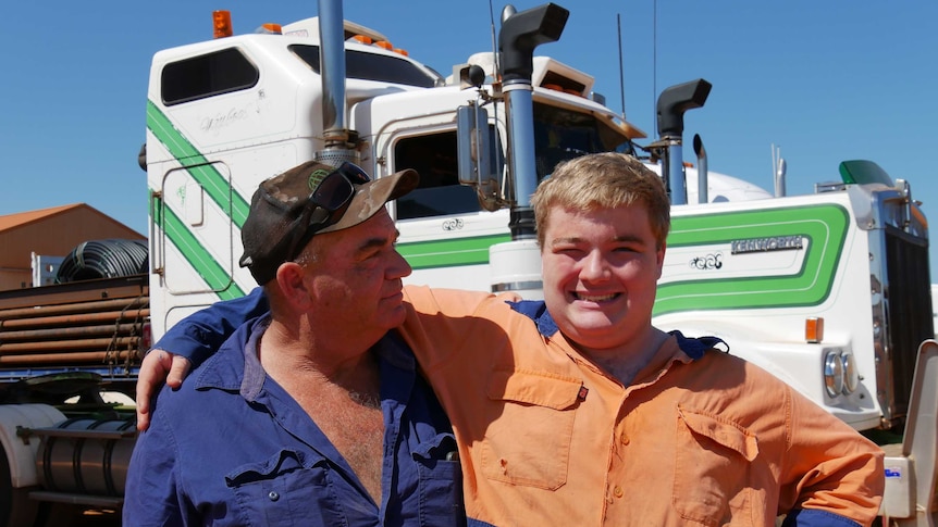 Kevin and William Anthony stand in front of their truck.