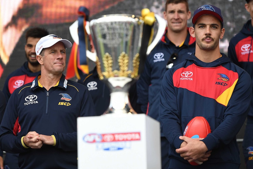 Don Pyke and Taylor Walker look at the AFL premiership cup.