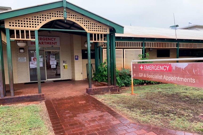 A small regional hospital's front entrance at the end of a red path.