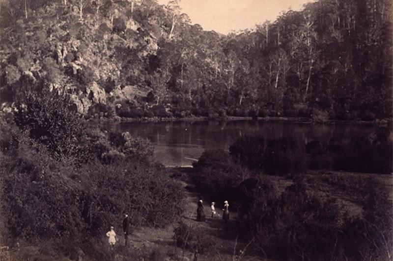 People stand near a watercourse.