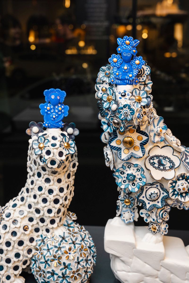 A series of four ceramic sculptures in white, gold and blue decorated with flowers and apertures