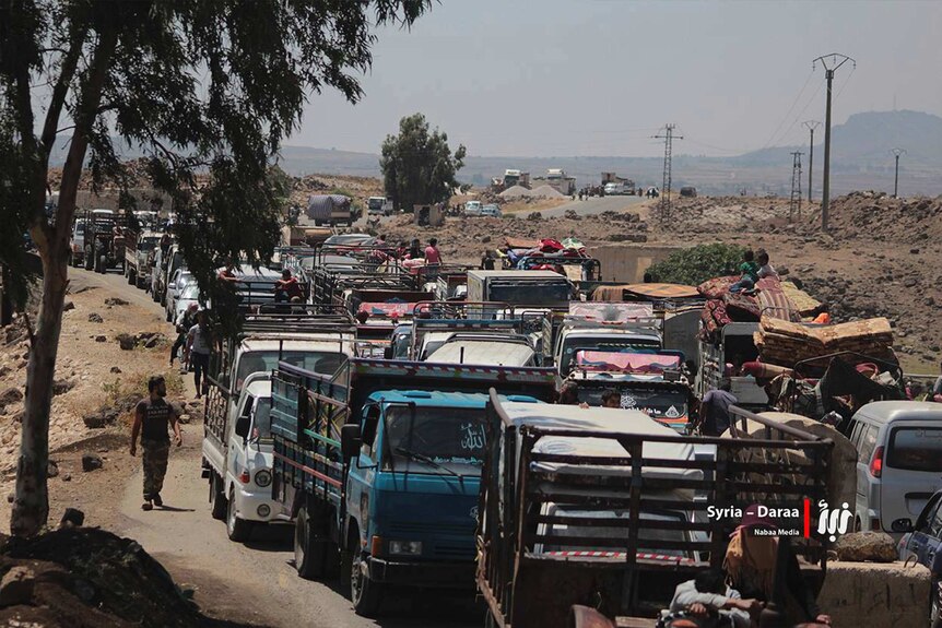 A long line of people in their vehicles fleeing from Daraa block the roads