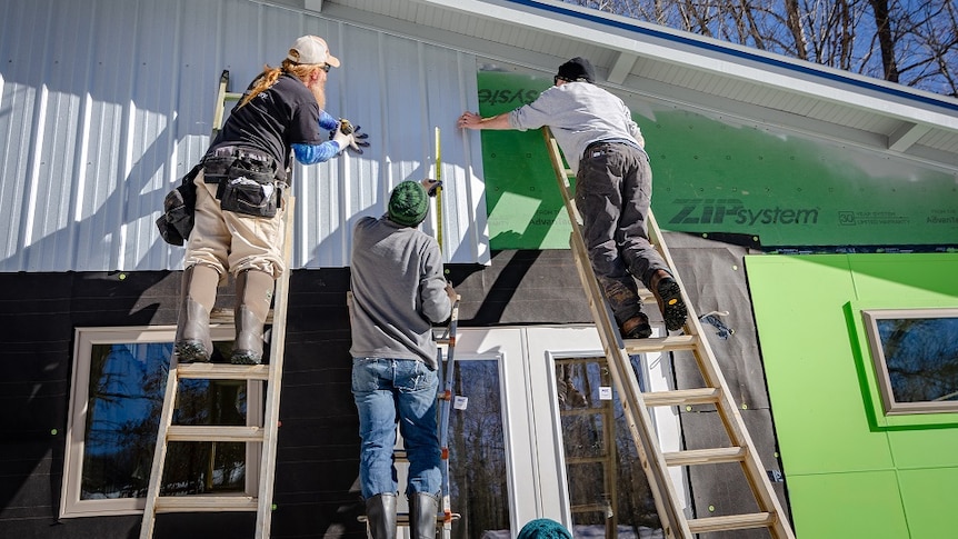 Carpenters working on a house for a story about the benefits of having an architect help with home renovations