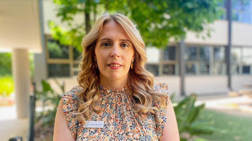 Melbourne teacher Siobhan Bloomfield, who has flowing blonde hair and is wearing a floral top outside.