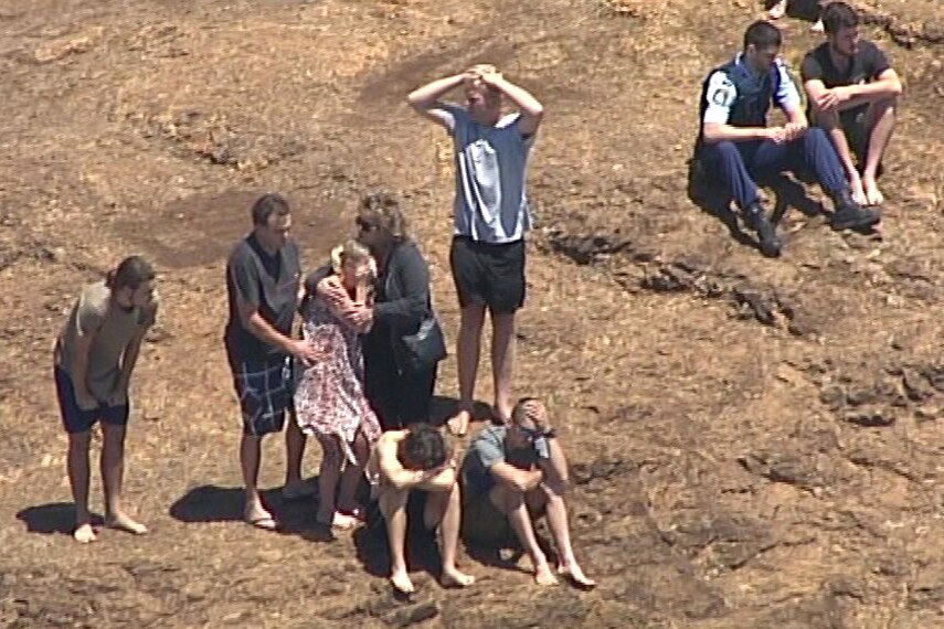 People watch on from Fingal Head as Police and Surf Lifesavers search for a missing bodyboarder.