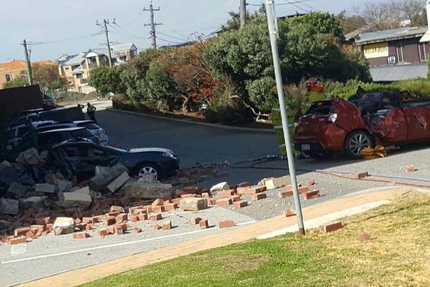 Fallen bricks surround two badly damaged cars in Fremantle