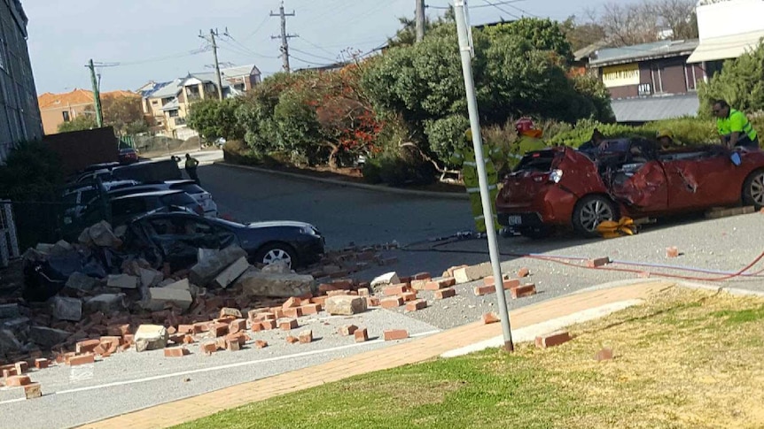 Fallen bricks surround two badly damaged cars in Fremantle