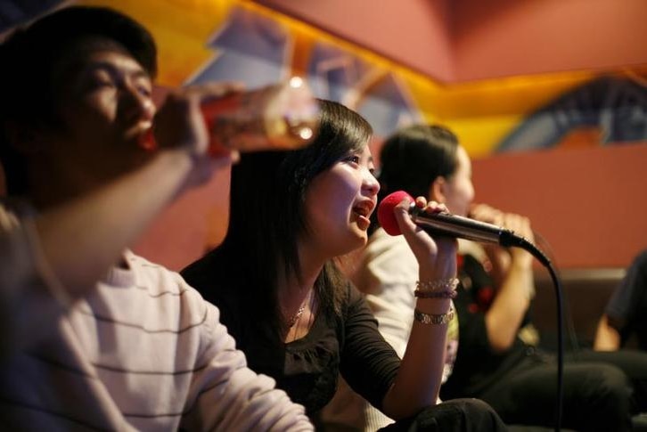 A group of friends sing in a local karaoke club during a night out