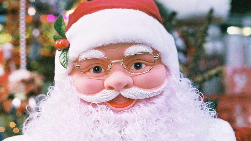 A model of Santa smiles at the camera