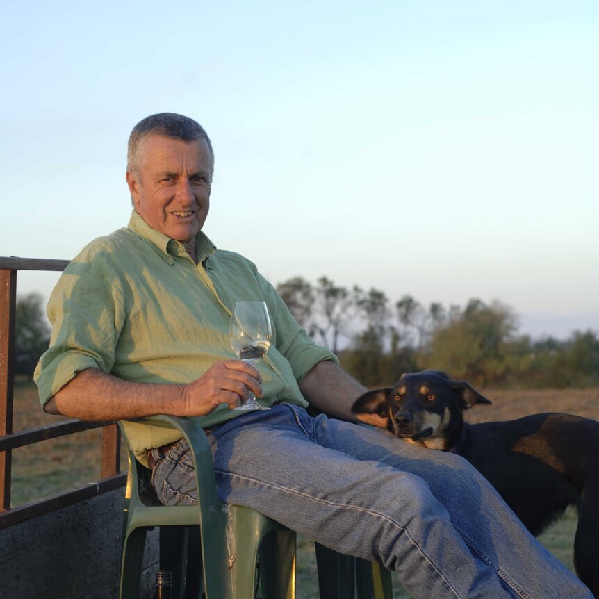 Winemaker with glass of wine and his dog