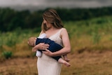 Melanie breastfeeding her son on her wedding day