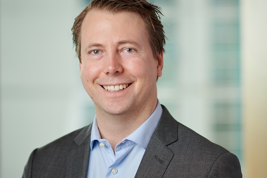 a smiling man in a jacket and shirt