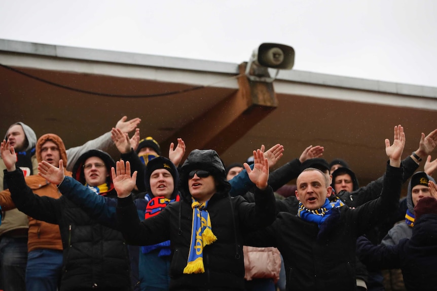 Fans cheer during a Belarus Championship soccer match.