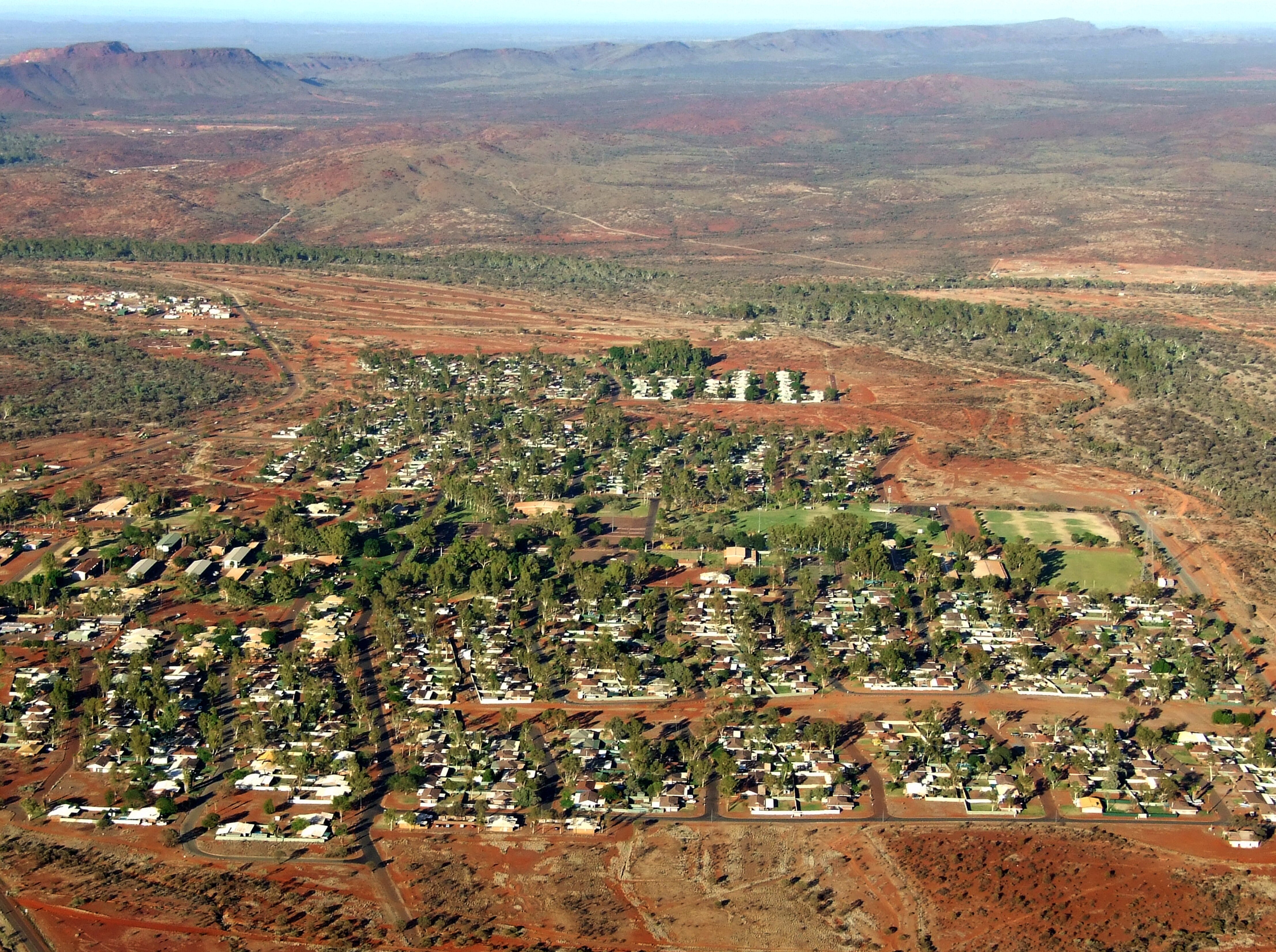 An aerial view of a town with red earth.