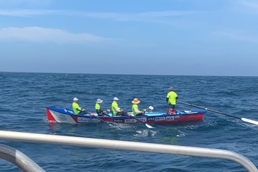 5 men in a surfboat at sea