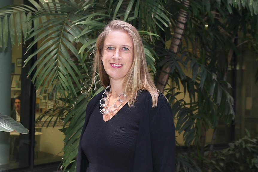 Professor Eske Derks stands and smiles at QIMR Berghofer medical research institution in Brisbane.