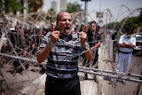 An Egyptian protester shouts in front of police outside the Supreme Constitutional Court.