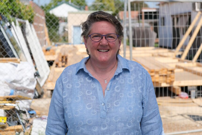 Professor Paula Gerber stands in front of a housing construction site
