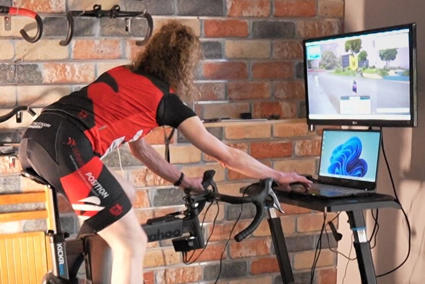 A woman on a bicycle that is hooked up to a computer.