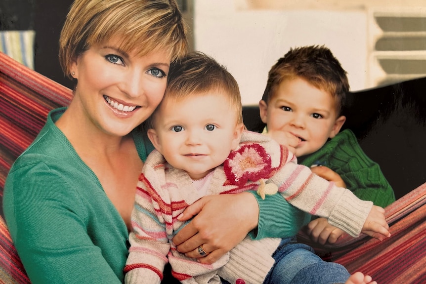 A magazine photo of a woman with her two young kids on a couch