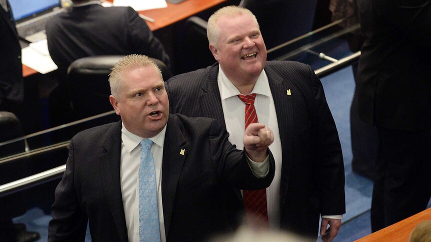 Toronto city councillor Doug Ford and his brother, mayor Rob Ford, react to hecklers in the public gallery.
