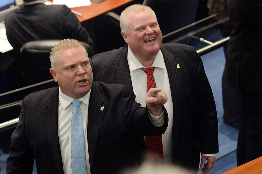 Toronto city councillor Doug Ford and his brother, mayor Rob Ford, react to hecklers in the public gallery.