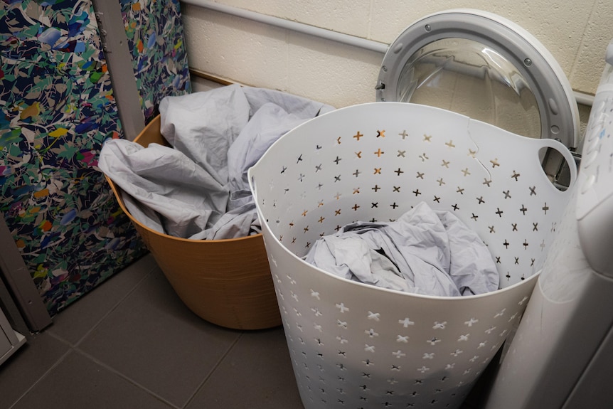 Laundry in  baskets in a utility room.
