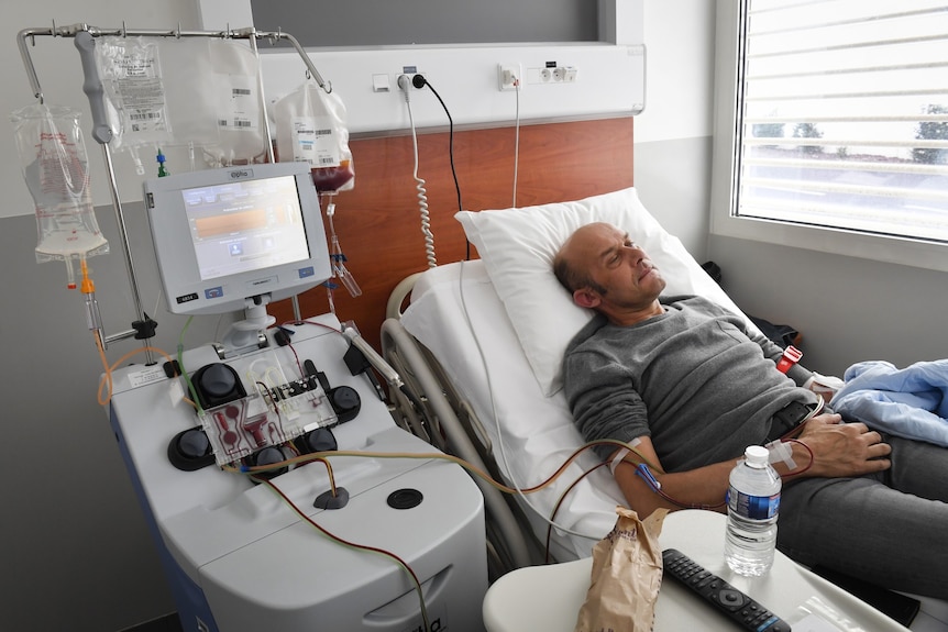 A Caucasian man lying in a hospital bed
