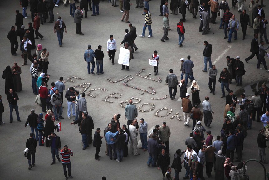 "We are the men of Facebook" is written on the ground as anti-government protesters gather in Tahrir Square.