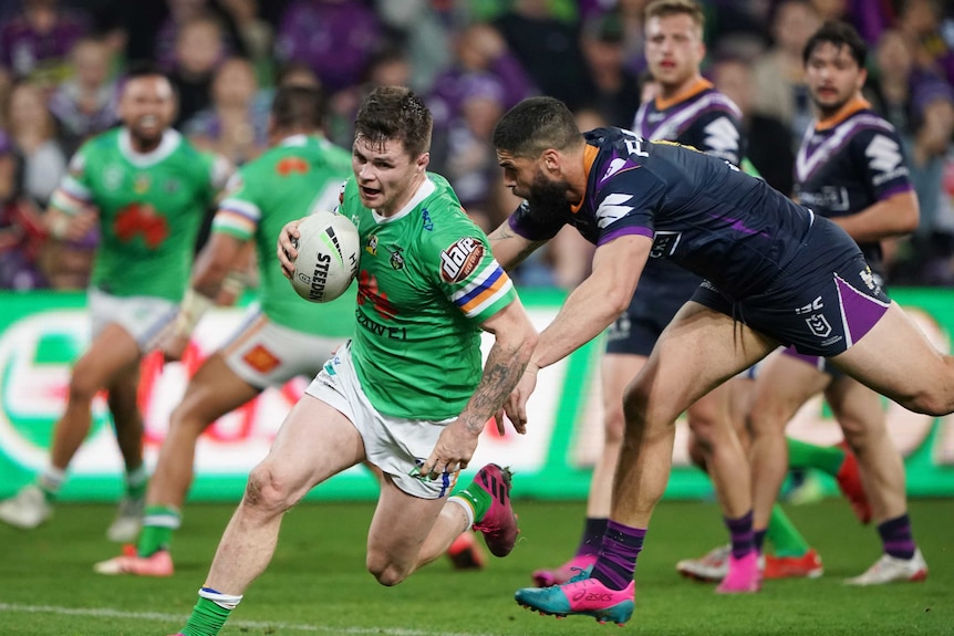 An NRL player evades a tackle to run in and score a try in a final.