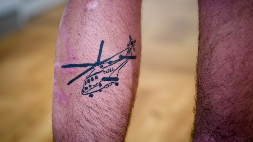 A tattoo of a helicopter on a leg.