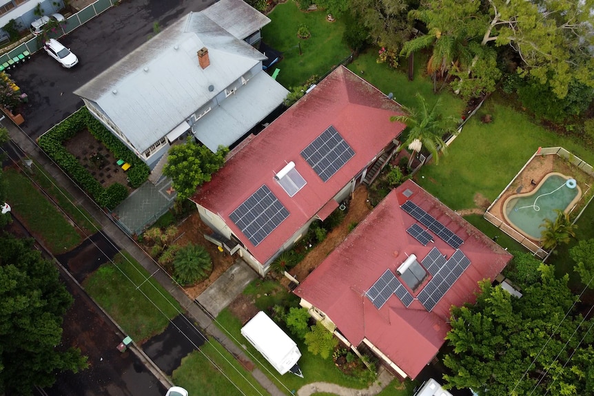 An aerial pic of the front of three neighbouring homes, all raised. One has a caravan out the front.