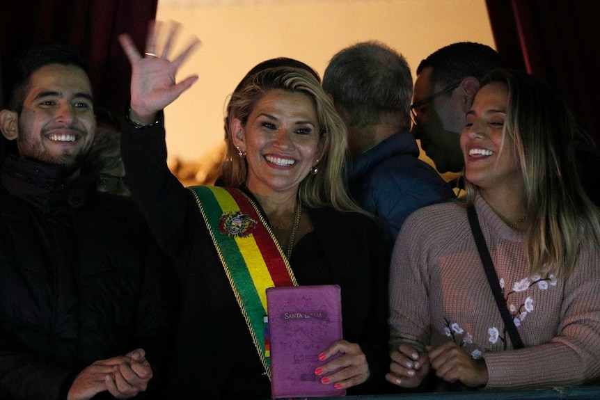 Bolivia's second Senate Vice President and opposition politician Jeanine Anez holding up a bible on a balcony.