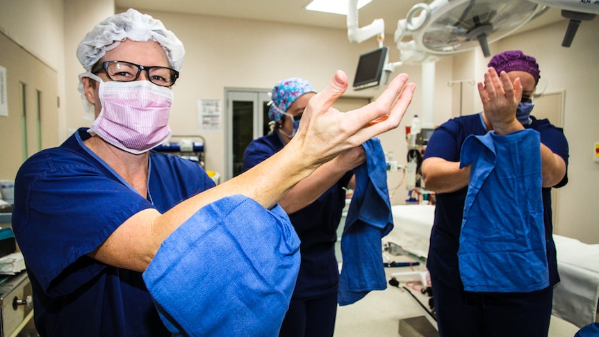 Theatre nurses Linda Carr, Kerry Schroder and Kerryn Giorgianni dry their hands in preparation for surgery.