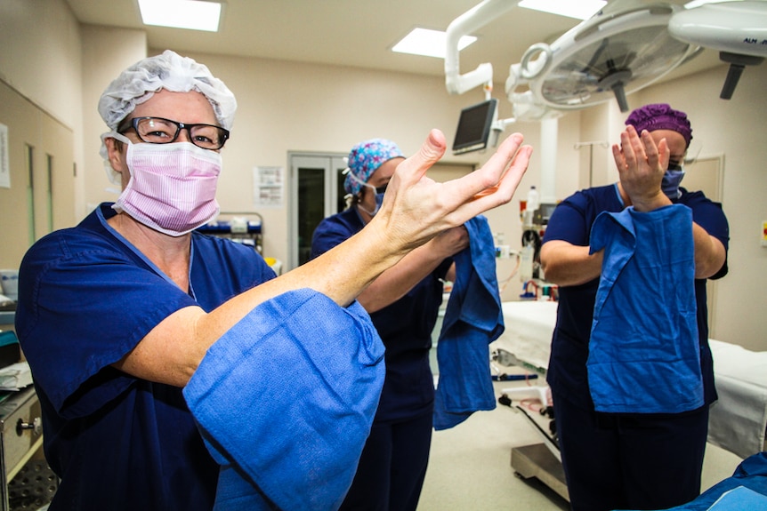Theatre nurses Linda Carr, Kerry Schroder and Kerryn Giorgianni dry their hands in preparation for surgery.